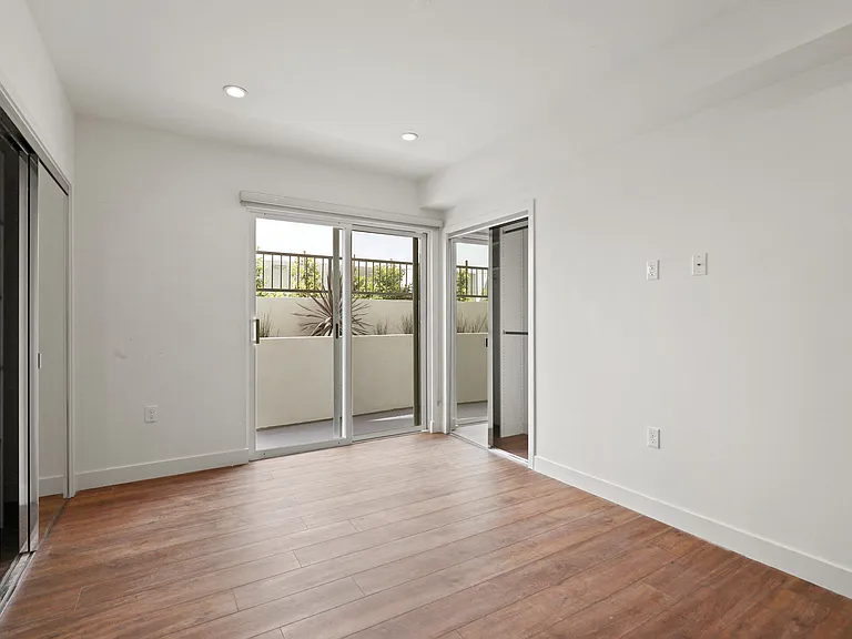 Bedroom with Two Closets, Vinyl Flooring, Recessed Lighting, and Patio