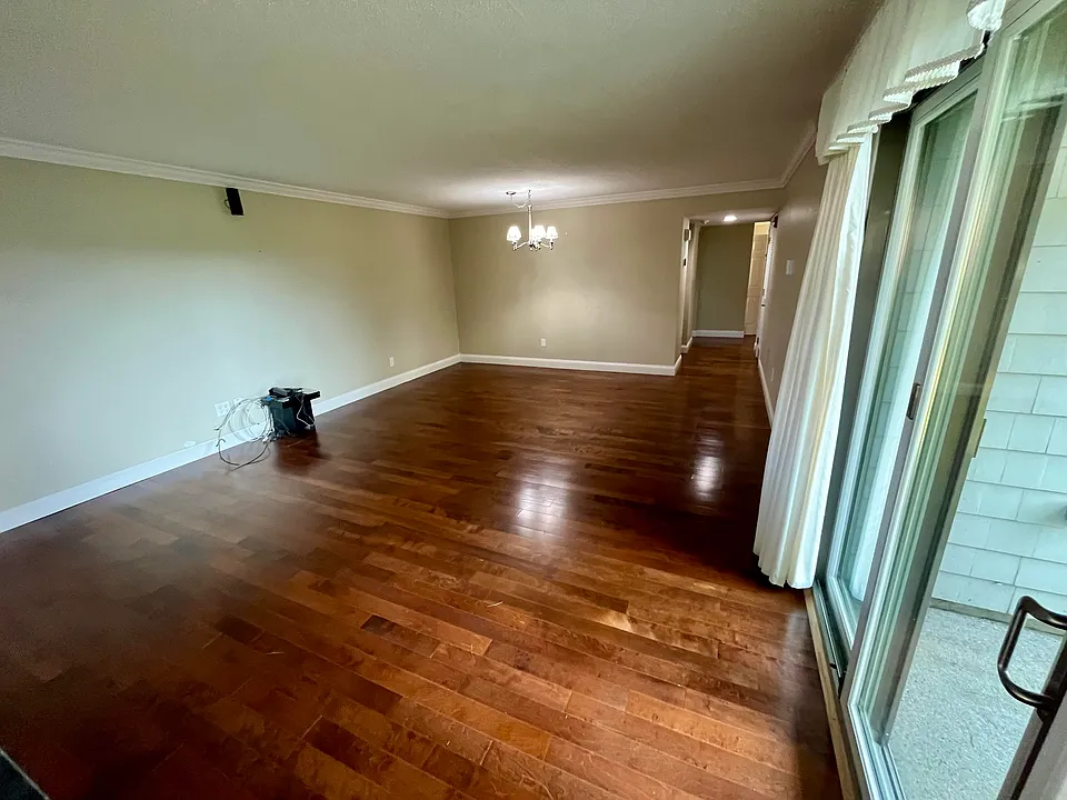 View of the dining area from the wall with the fireplace. The door to the patio is to the right. The kitchen lies just beyond