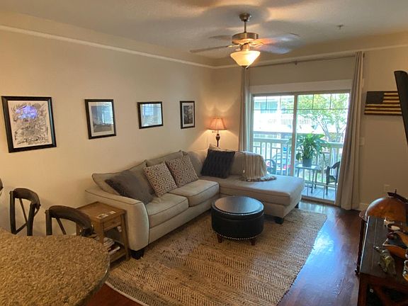 Living room with sliding screen door opening to porch that can seat two.