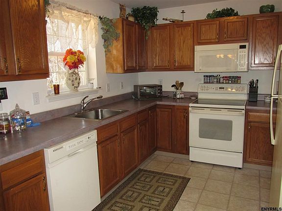 Dishwasher, electric range, refrigerator, pantry, oak cabinets, vinyl flooring.