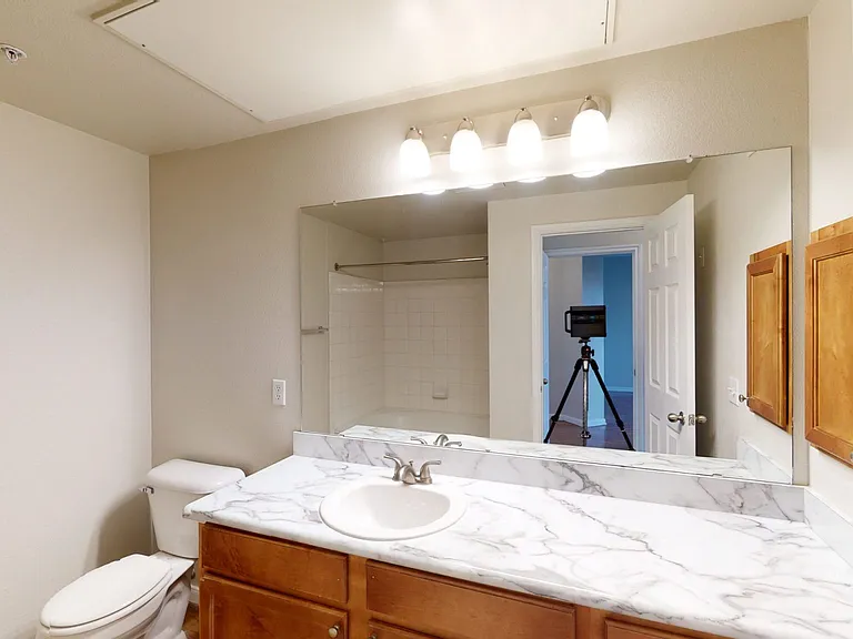 Apartment bathroom with wood-style flooring.