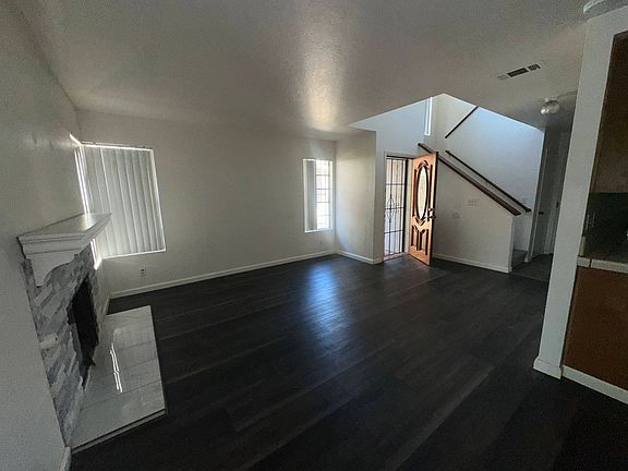 Living room area and marble fire place. Screen door and wooden door entry.
