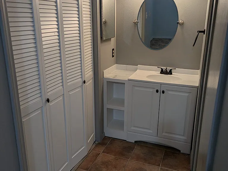 Vanity area, with folding closet doors on the left.