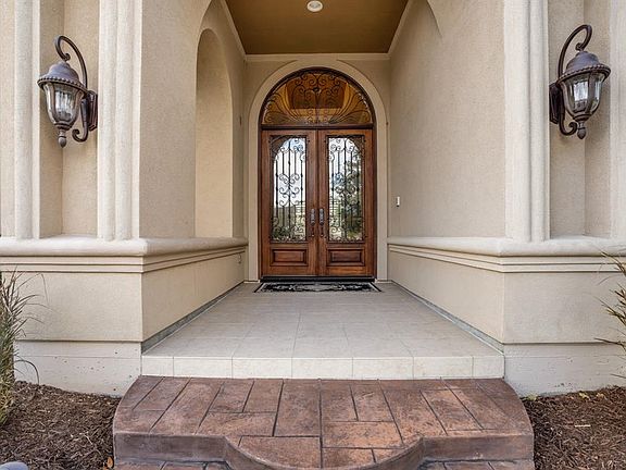 Incredible inviting front porch leads through gorgeous double wrought iron, glass and wooden door into a beautiful 1 story home.