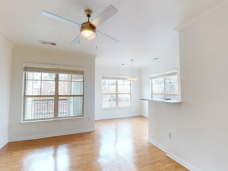 Apartment dining and living room with wood-style flooring.