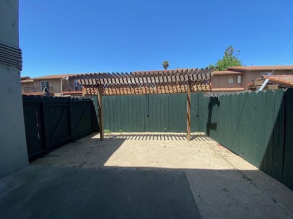 Living room opens out to private backyard patio with trellis.