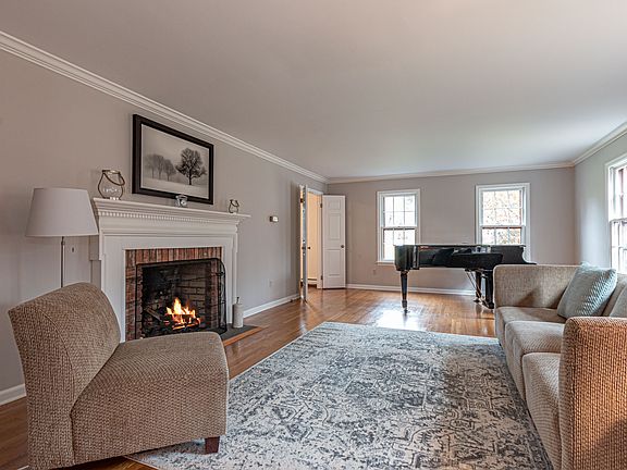 Large formal living room with elegant fireplace, hardwood floors and crown molding