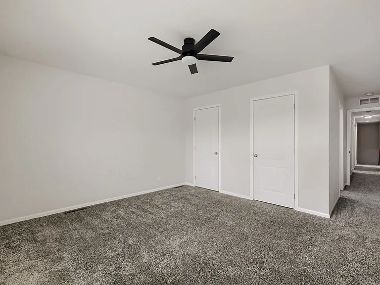 Master bedroom with walk-in closet and ceiling fan