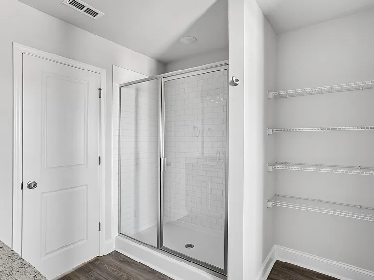 Alternate view of walk-in shower and linen storage.