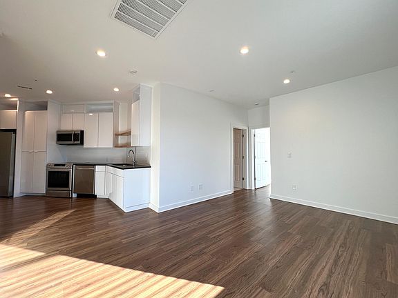 Living room view towards kitchen, bathroom 2, and bedroom 2.