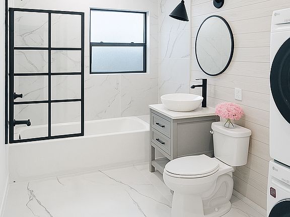 Full bathroom with shower, tub, and washer/dryer