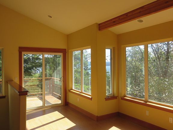 the open living room/kitchen is light and airy with filtered water view looking toward Orcas Island.