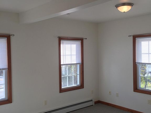 Living Room has carpet and three windows for natural light.