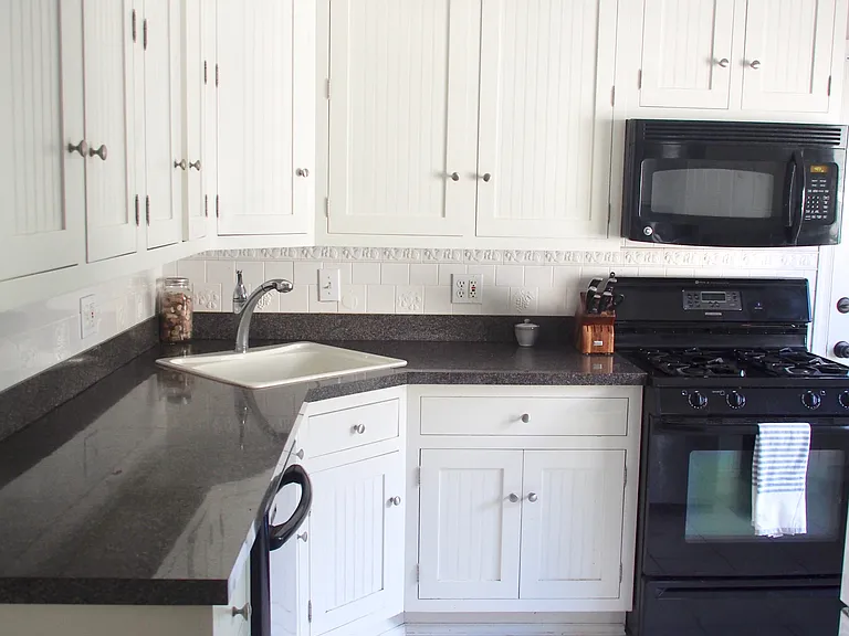 Spacious, light filled kitchen with door to the backyard.