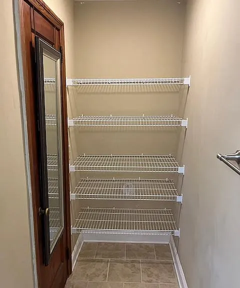 Door from master into walk-in closet with more shelving for towels, supplies, etc.