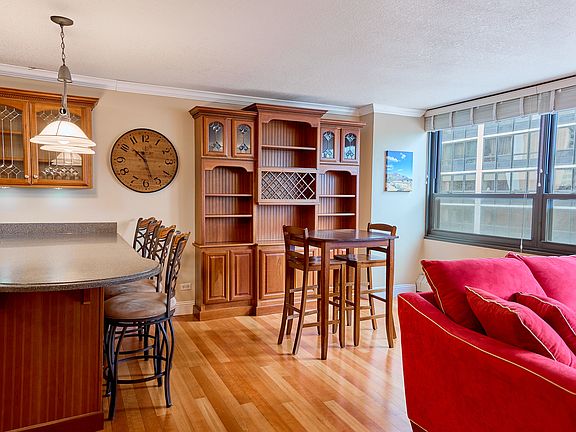Open kitchen layout features large custom wood cabinetry for ample storage and a cozy high-top table for two_ideal for casual dining or morning coffee