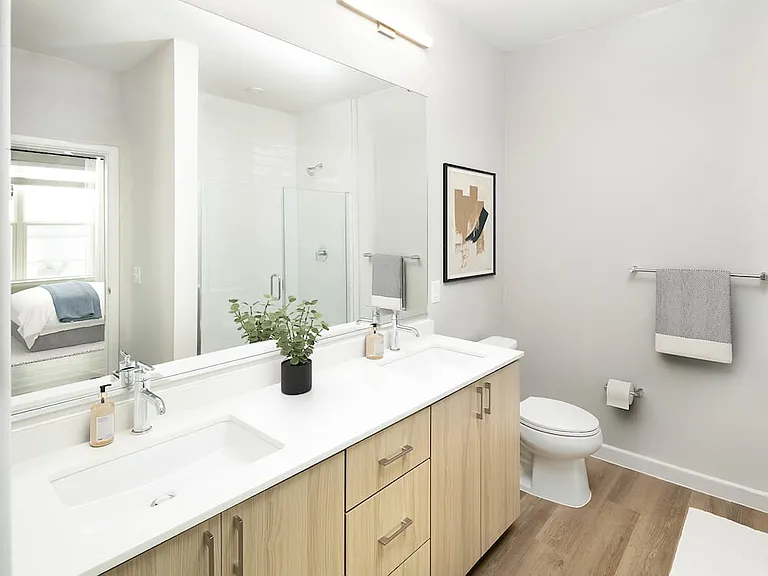 Finish Package II bath with oak cabinetry, white quartz countertop, and hard surface flooring