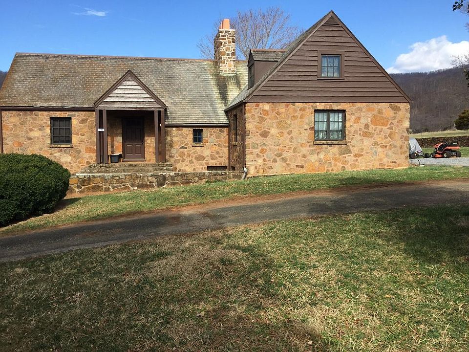 Formal entrance to the house has a patio with room for a table and chairs. The side entrance to the right has another door with parking.