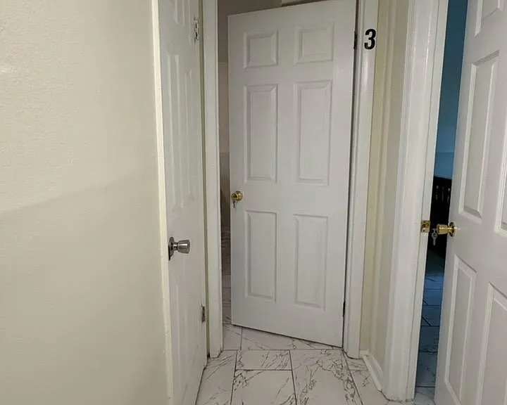 Tile-floored interior hallway connecting multiple rooms with convenient access to nearby bedrooms and bath areas.