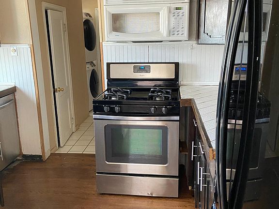 Kitchen leading to 1/2 bath with washer dryer hookup and back door.