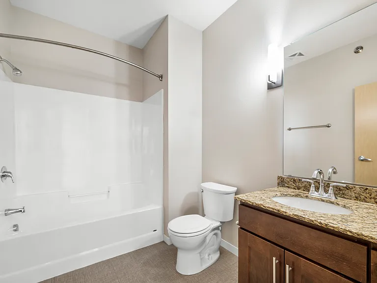 Modern bathroom featuring a sleek granite countertop, elegant fixtures, and a pristine bathtub. Modern bathroom featuring a sleek granite countertop, elegant fixtures, and a pristine bathtub.