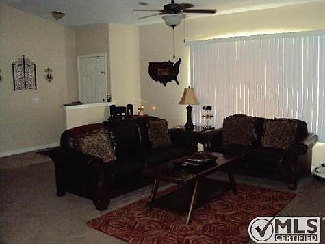 Ceiling fan in family room, carpet and window coverings.
