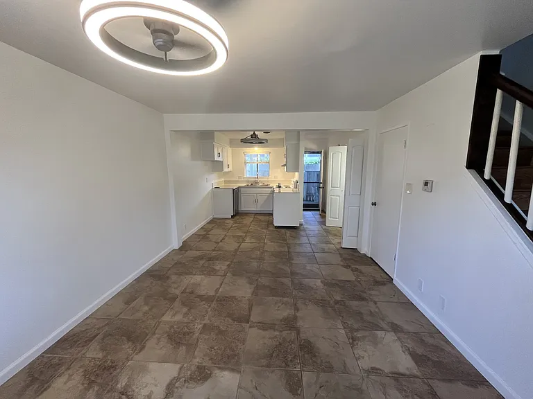 living room overlooking kitchen and door to private patio with a screen door. Laundry closet on the left and 1/2 bath on the left. 2 ceiling fan/light fixtures. Update kitchen with quartz counters and shaker door cabinets. Updated nice shite paint.