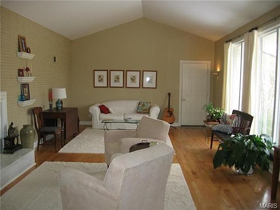 Large living room with vaulted ceiling and woodburning fireplace