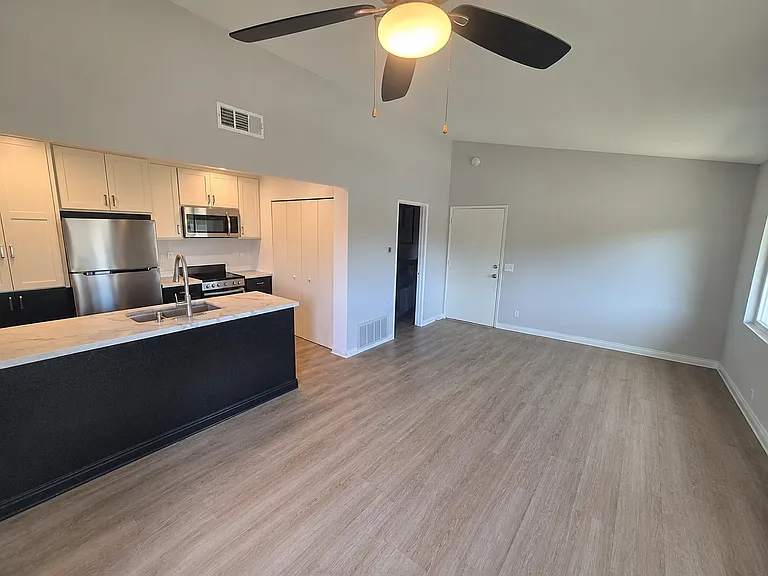 Kitchen Island, Refrigerator, Microwave, Stove. View of front door and Living Room area
