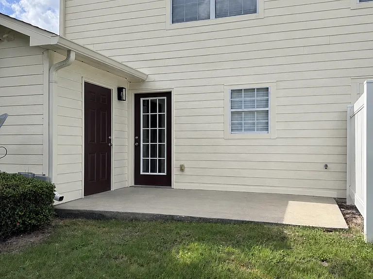 Back patio with entry door in to the kitchen and storage room on the left.