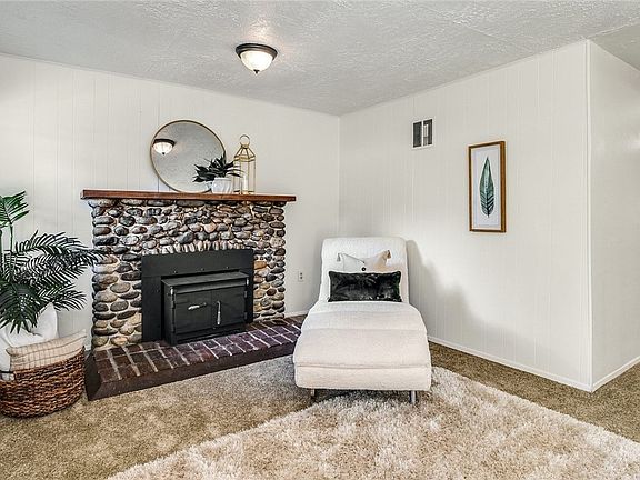 Wood burning stone fireplace in living room.