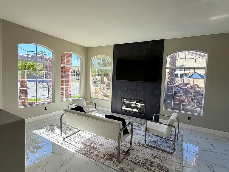 Dedicated seating area centered around a contemporary fireplace with floor-to-ceiling tile detail and a wall-mounted TV.