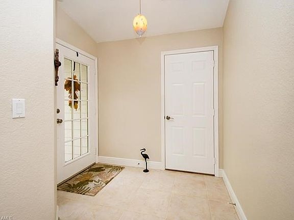 A large welcoming foyer shows the entrance to the left and the door out to the oversized two garage.