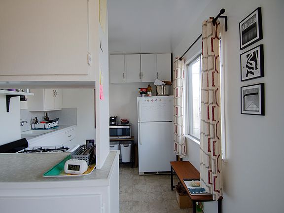 Kitchen from living room (ceiling fan w/ lights not visible but looks like the one in the bedroom).