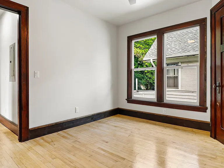 This shot shows the first bedroom --and to the left, you see the hallway leading into the hall between bedrooms with a doorway into the kitchen. There is a back door exit way from the kitchen. AND A PORCH!