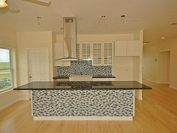 Island kitchen with mosaic tile detail on back splash and island