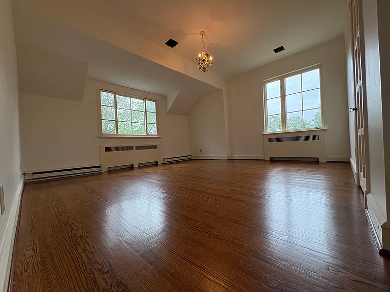Large bedroom with architectural details in ceiling. Floors redone in 2025 and walls and ceiling reskimmed and painted in 2025.