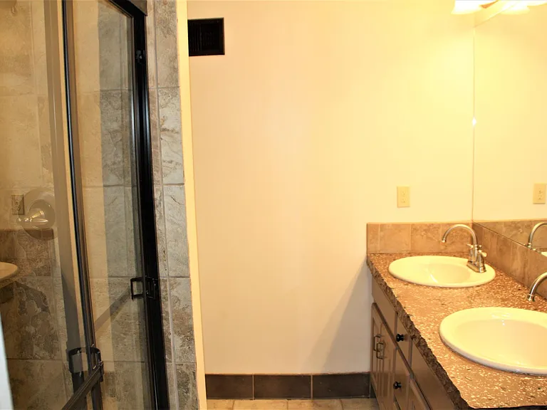Master bathroom with tile flooring. concrete counters