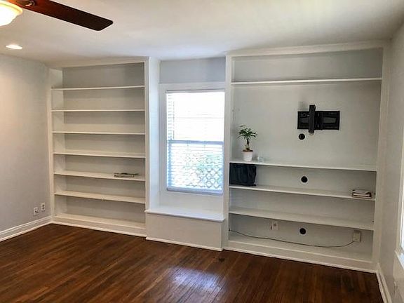 Built-in bookcases, window seat, and TV anchor in living room