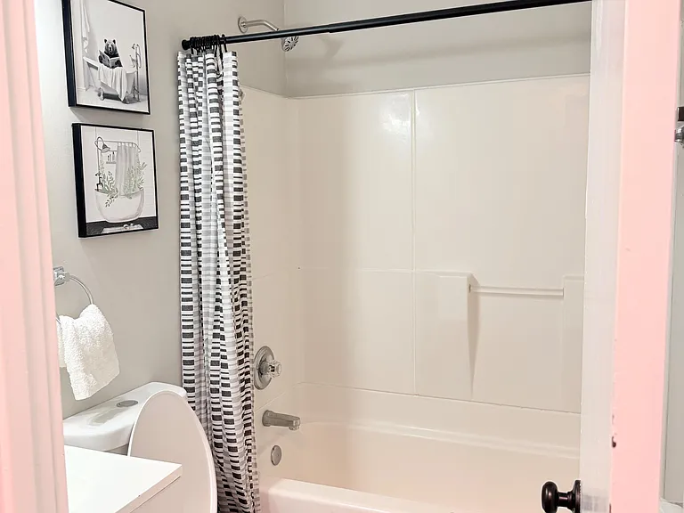 Full bath with tub/shower combo, easy-clean surround, and vanity storage for daily essentials.