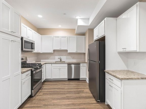 View of gourmet kitchen with white cabinets, granite countertops and stainless steel appliances