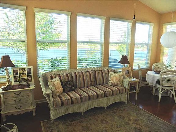 Sun Room. The Sun Room features three walls of windows with gorgeous lake views.  It also boasts a tall vaulted ceiling, hardwood floors, and a door leads to the large entertainment patio.