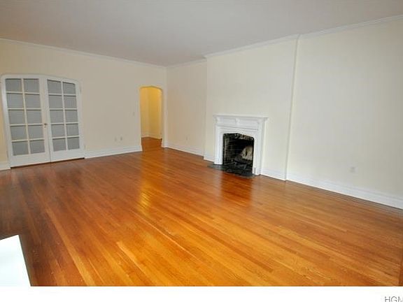 Large living room with working fireplace, large closet with french doors and refinished hardwood floors.  The room is 21'-11" x 15'-7".