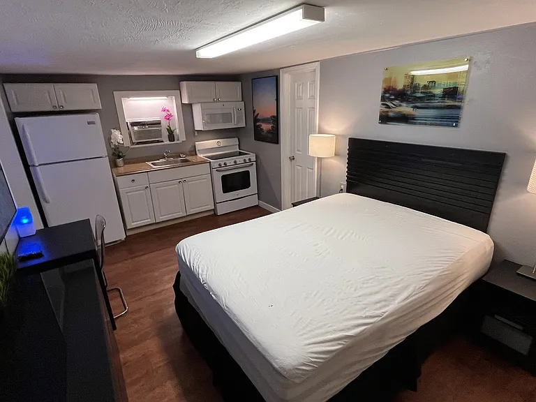 Queen bed, dual night stands with lamps, dresser, desk and chair, 65in Smart TV, full kitchen, bath.