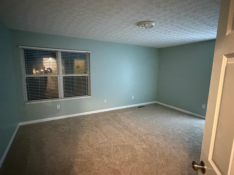 Master bedroom with double window and walk-in closet.