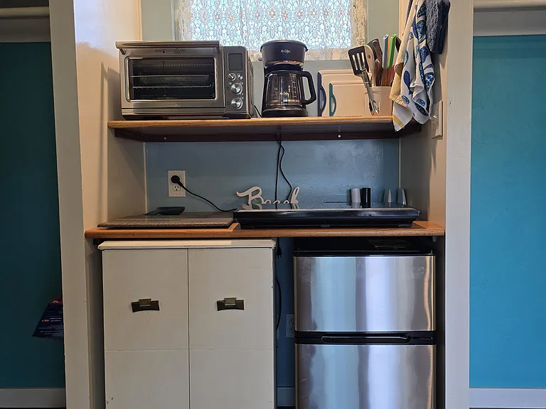 Kitchenette with new convection oven, coffeemaker, cooktop, new mini-refrigerator, and pantry.