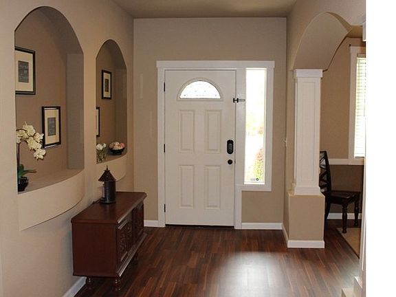 Ample Elegant entry welcomes guests, art niches and archway with pillars to dining room add lots of style.