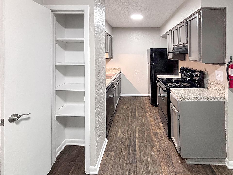 Enjoy a functional kitchen with sleek black appliances and built-in shelving at Christy Estates Apartments.
