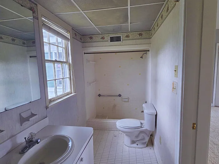 Clean, well-kept bathroom featuring shower, toilet, sink & mirror