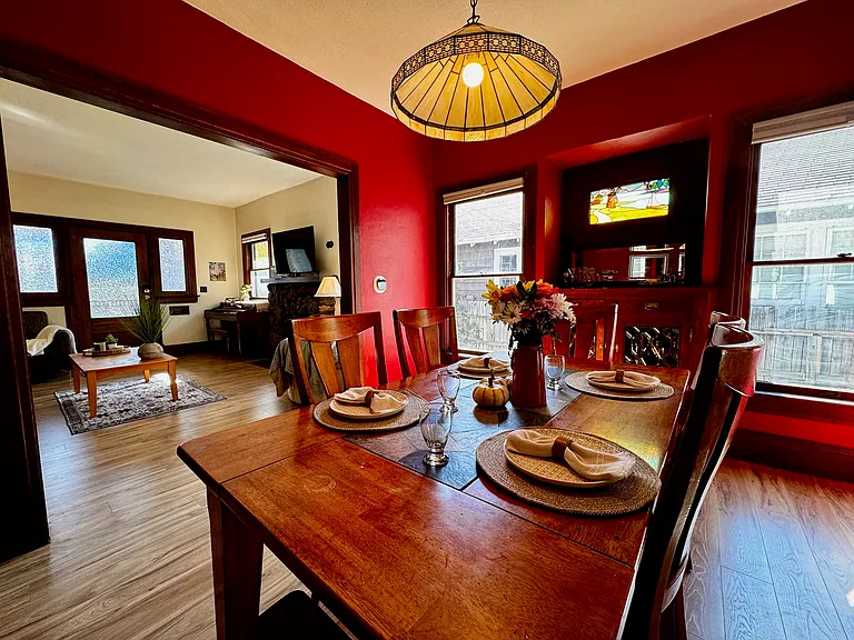 large dining room. Table seats six comfortably. Antique lamp and original stained glass and built-in cabinet.